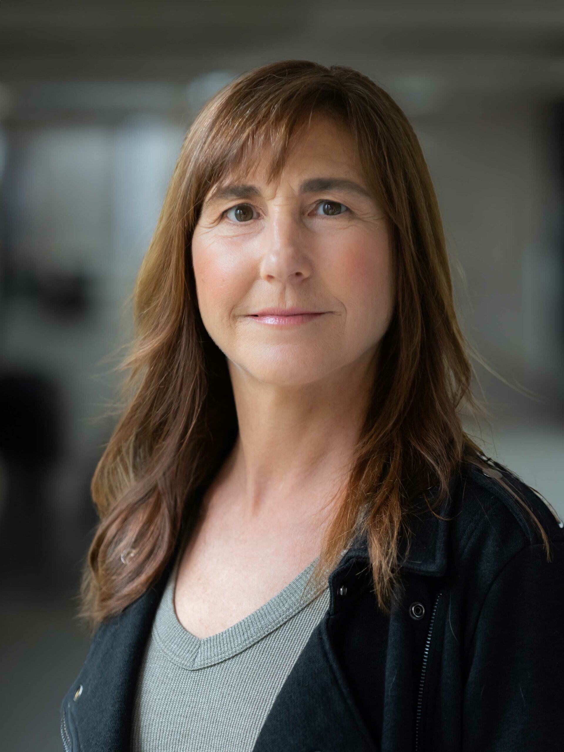 A professional headshot of a woman, Nancy Corderman. She has medium length brown hair styled with bangs. She has a soft smile and looks directly ahead.
