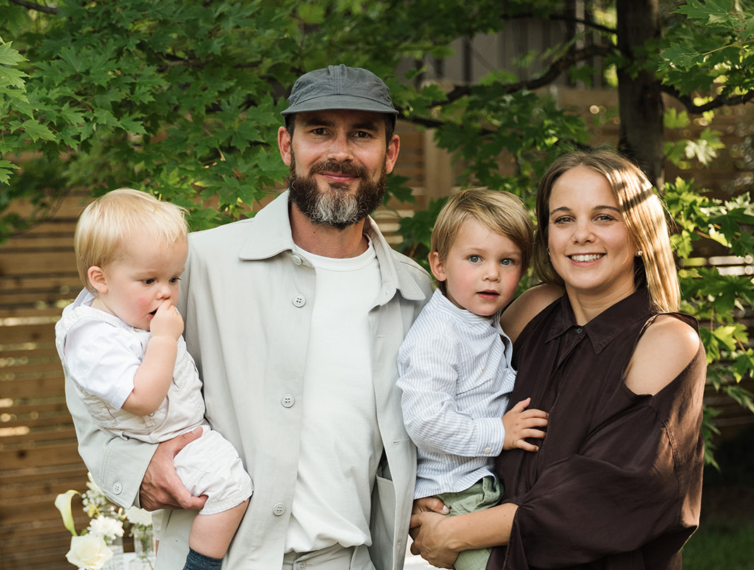 Family Photo A family photo of the Pochon family featuring both parents who are holding two young boys.