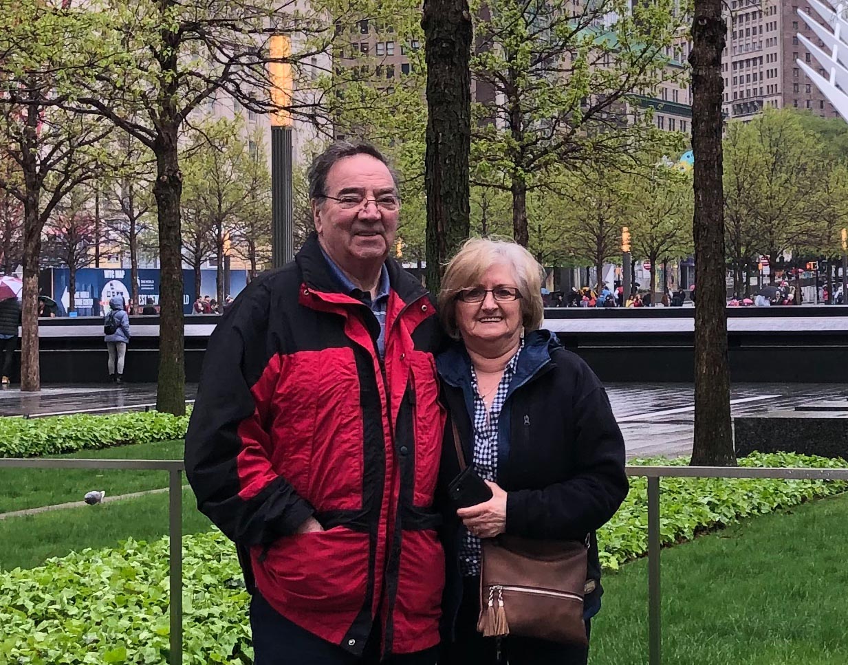 Fran and John Hickmott in 2019 standing in front of the World Trade Center memorial in New York City.
