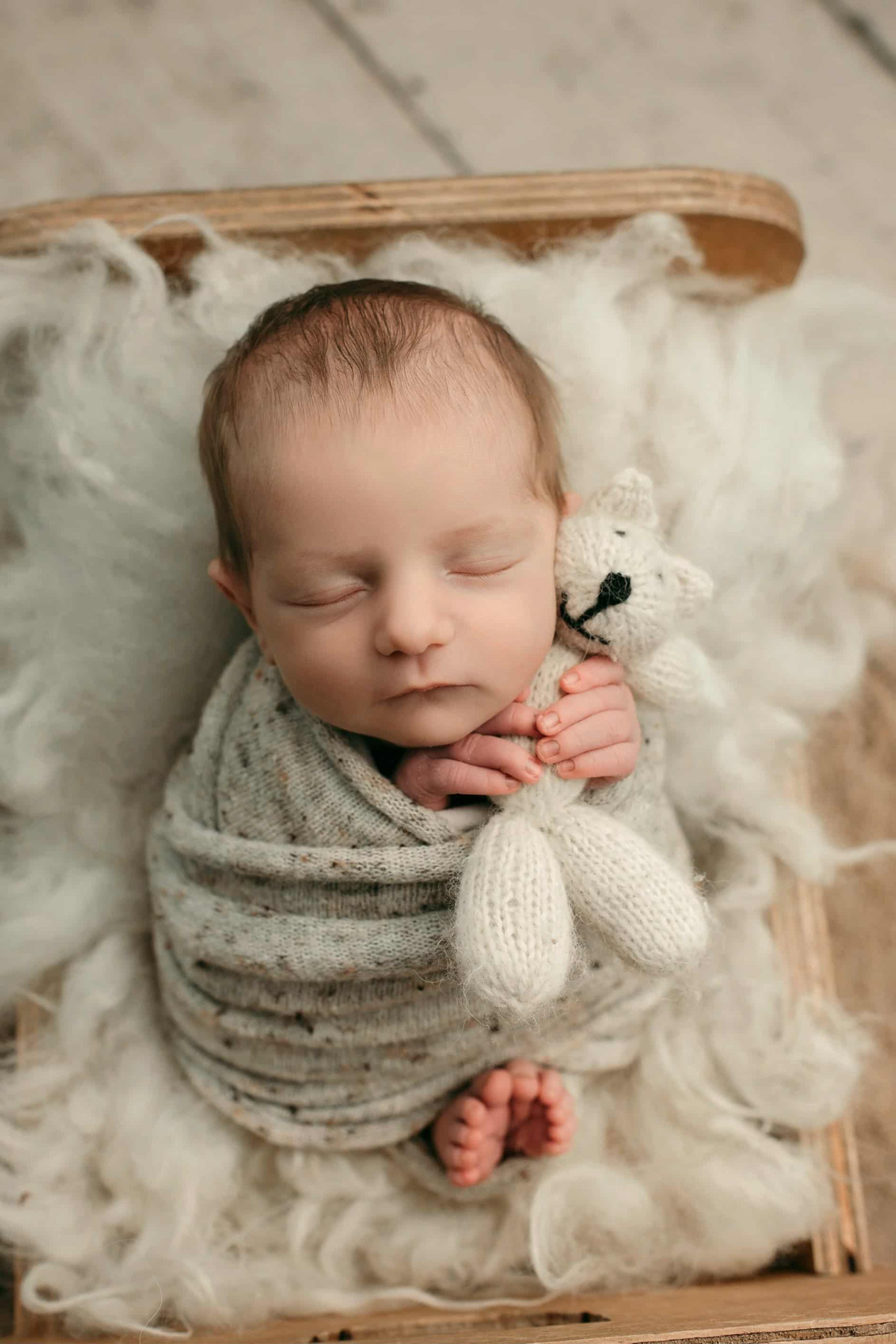 Joey sits on a grey couch with a big smile on his face