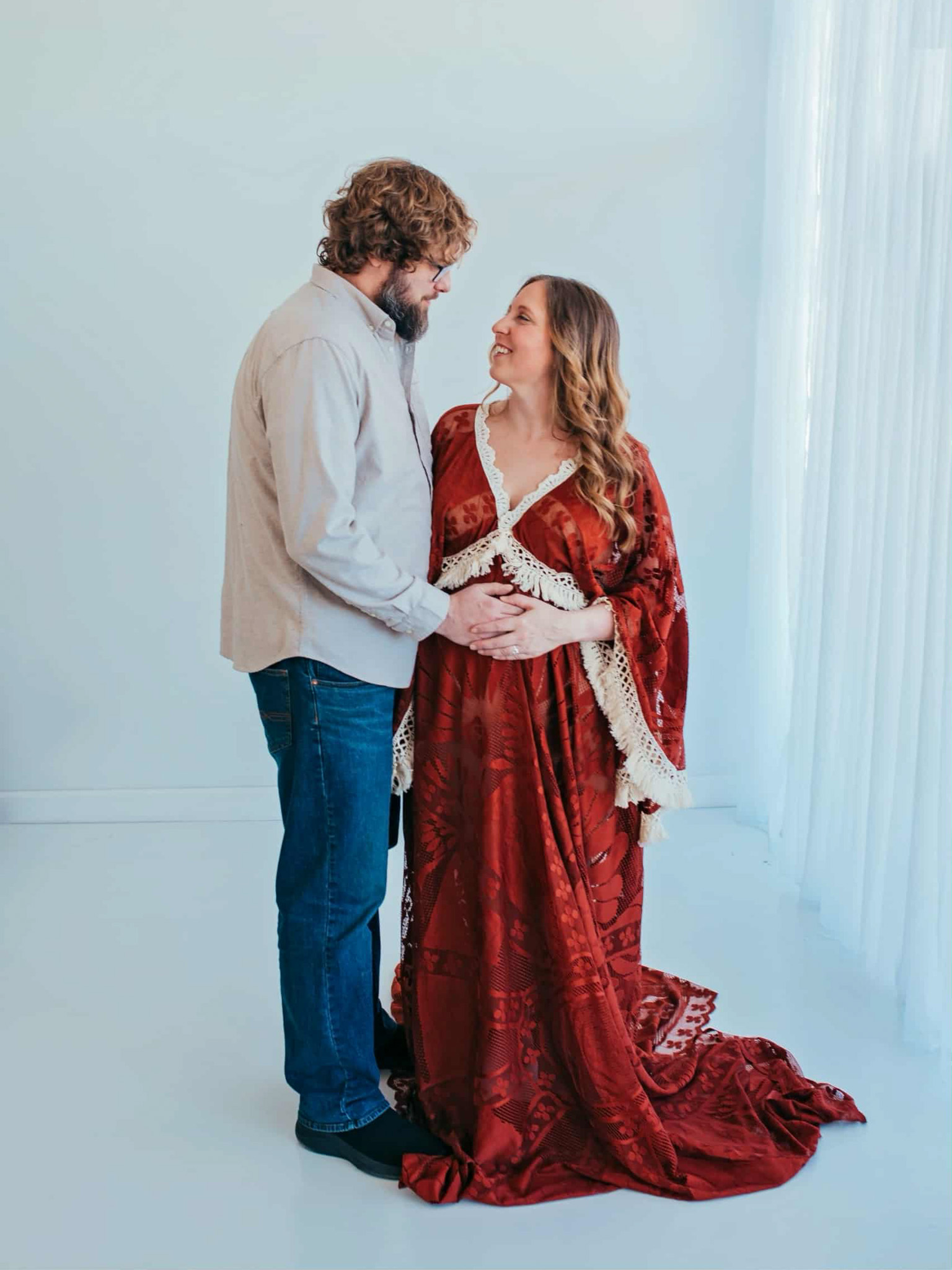 Joey sits on a grey couch with a big smile on his face