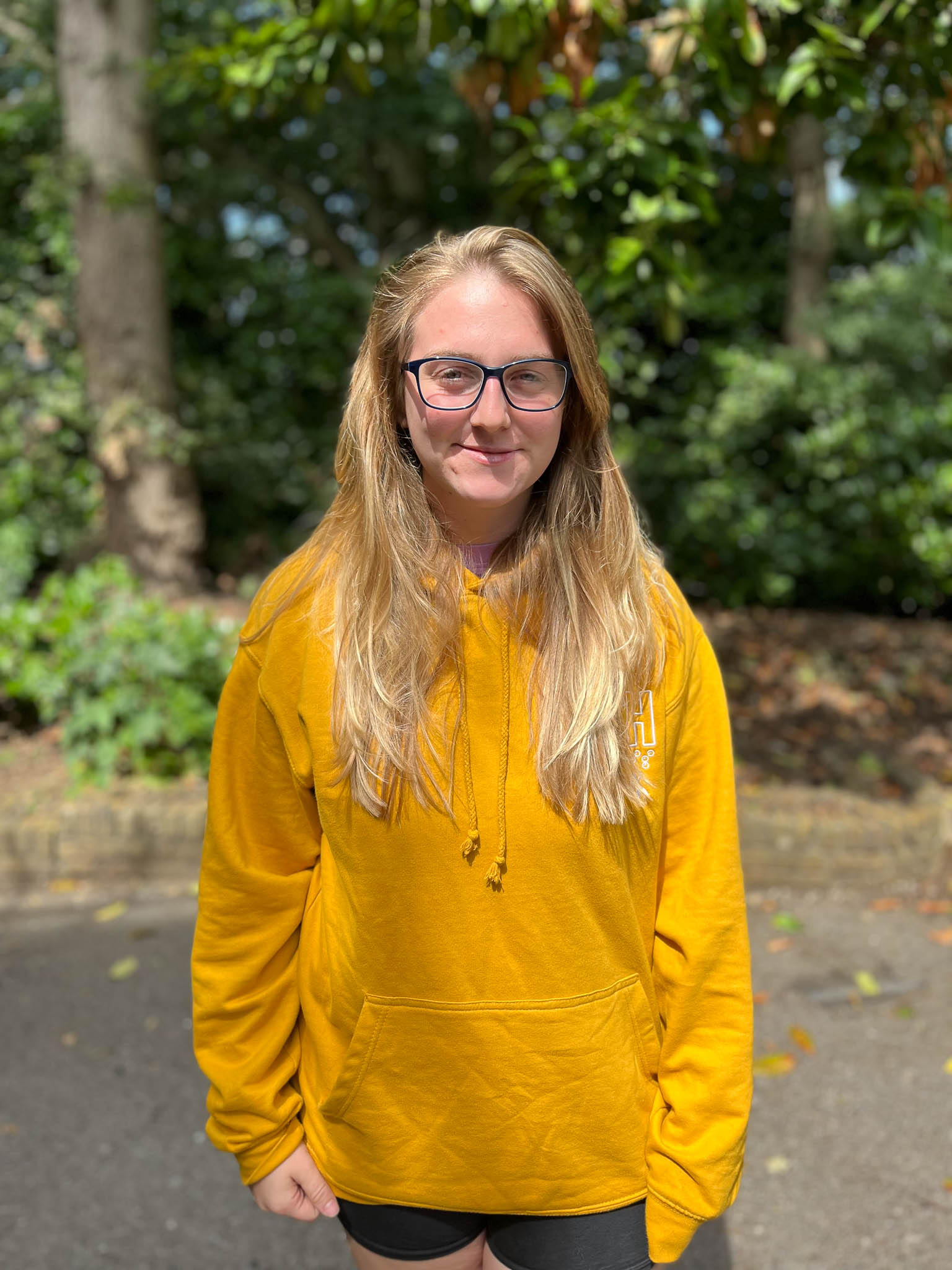 Chloe at the 2023 USHthis UK camp wearing a long sleeved yellow hoodie sweatshirt.