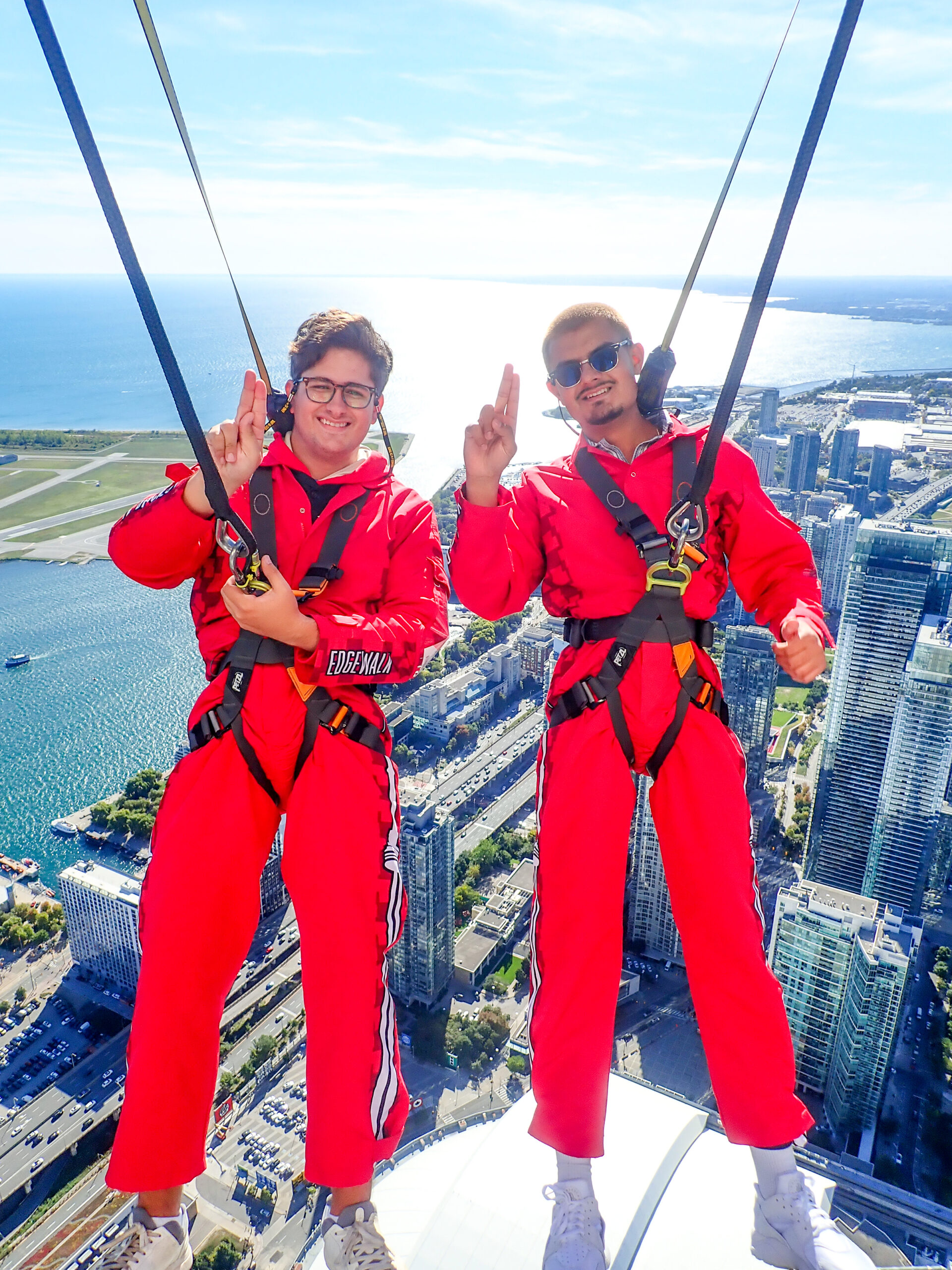 Awais and Ethan (Morrobel) crUSHed it during the Edge Walk at the CN Tower (2025). They are doing a handshape of "U" representing USH This. 