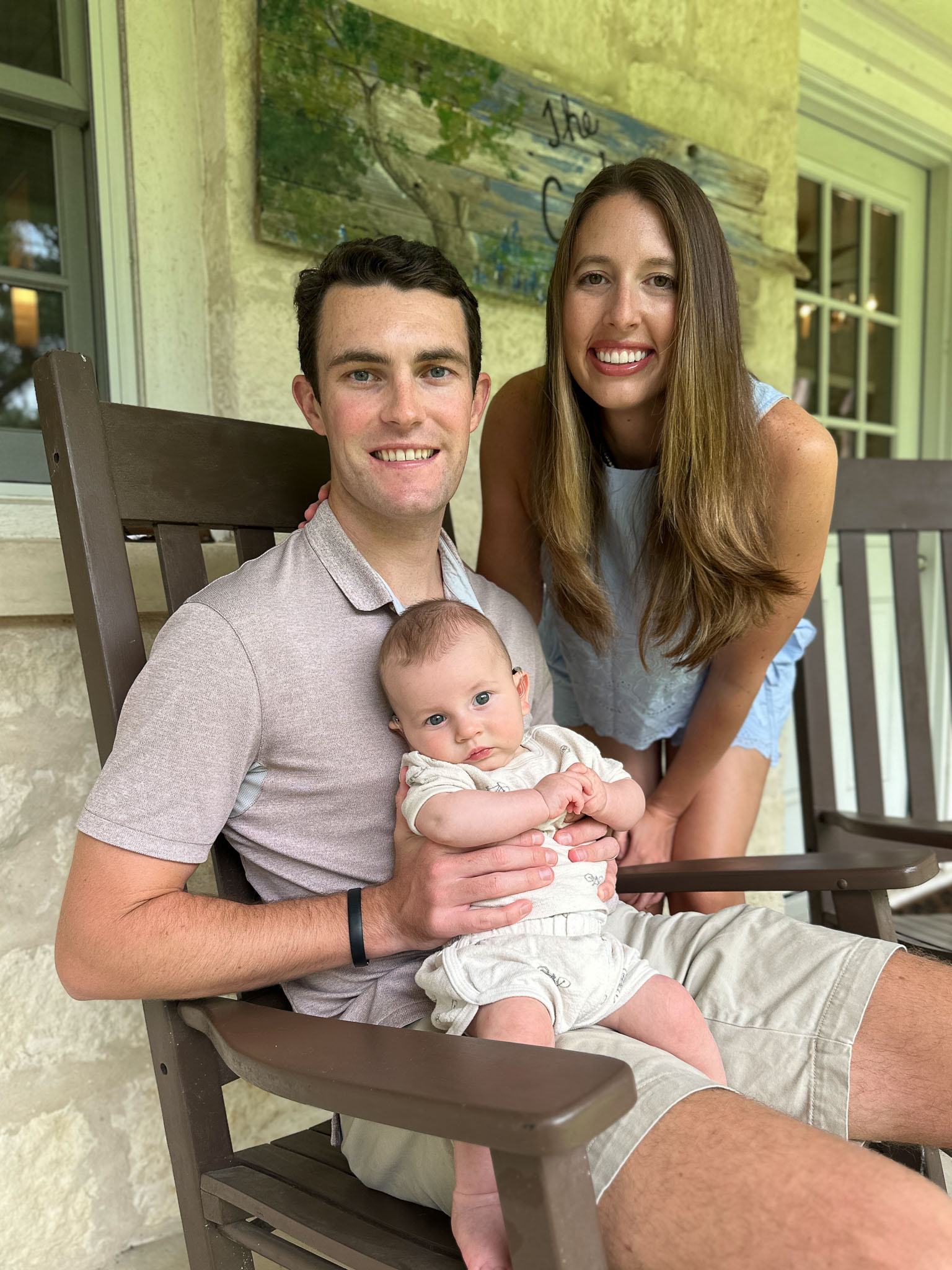 A photo of Griffins parents on a porch holding baby Griffin