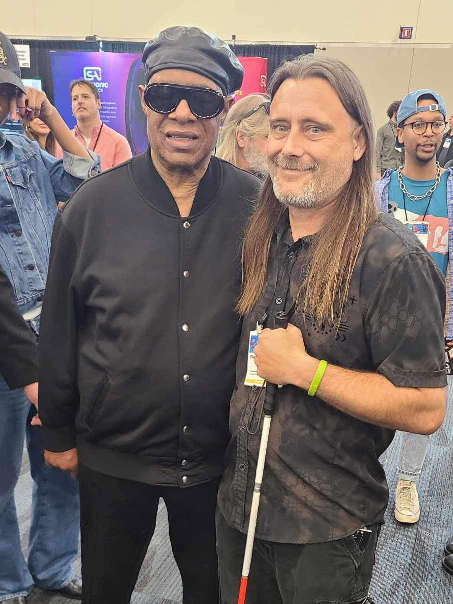 Nathan Stockton captures a memorable moment with legendary musician Stevie Wonder after a handler spotted Stockton's "That Blind Deaf Guy" badge at a 2025 music trade convention.